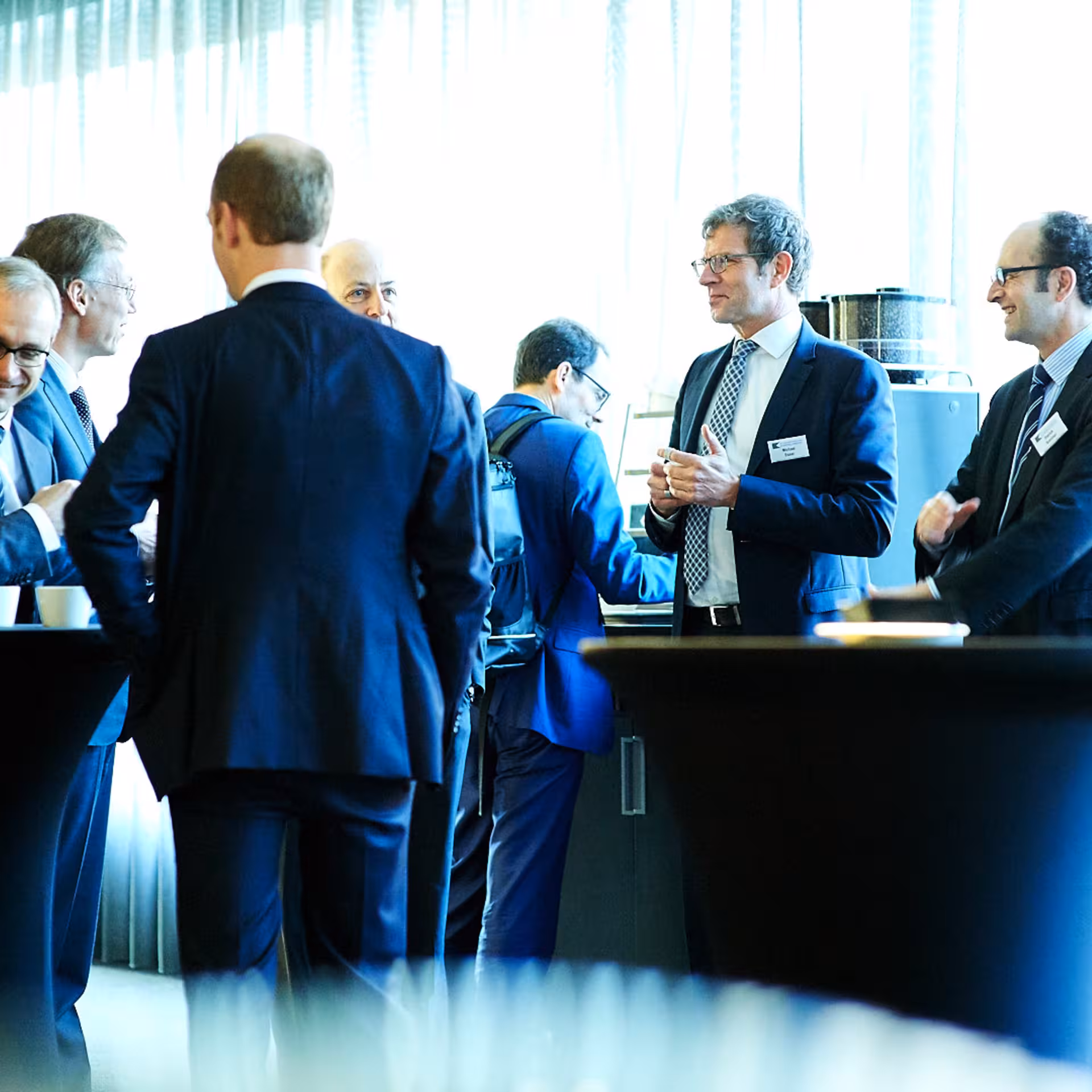 Menschen im Gespräch an Stehtischen